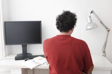 Masaüstü pc ile masaya oturan dizüstü kullanan adam