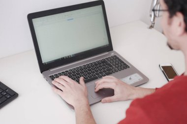 ofiste masada oturan dizüstü kullanan adam