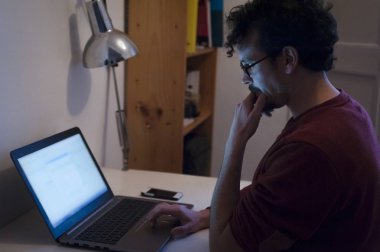 ofiste masada oturan dizüstü kullanan adam