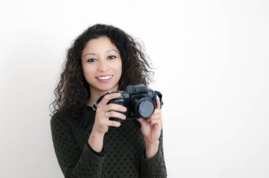 Beyaz arka plan ile bir refleks fotoğraf makinesi olan latin kadın