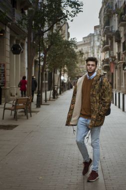 Sokakta yürüyen yakışıklı genç adam.