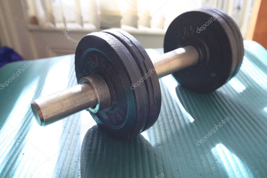 Close-up of dumbbell with window light on background.