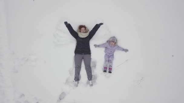 妈妈带着孩子在雪地的草地上玩耍 冬天在大自然中 — 图库视频影像