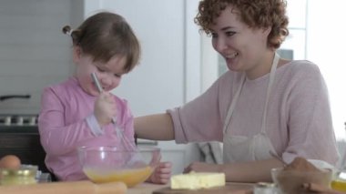 Annesi ve kızı mutfakta hamuru tabakta yoğuruyor. Bir kız mutfakta yaramazdır. Annesi aşçı olan küçük kızıyla oynuyor. Anne çocuğuna yemek yapmayı öğretir. Neşeli yemek pişirme.