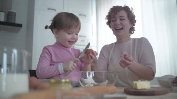 Córka Matka Rozbijają Jajka Misce Mama Uczy Córkę Gotować Dziewczyna — Wideo stockowe