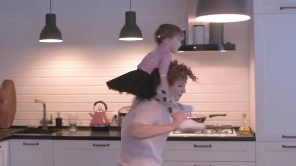 小女孩在厨房里鬼混 妈妈和女儿在一起很开心 妈妈在绕着她女儿转 那女孩在妈妈身边爬来爬去 妈妈和女儿在厨房玩得开心 — 图库视频影像