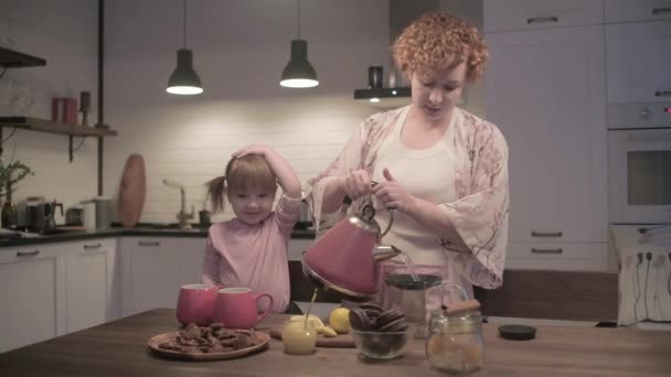 Νέα Όμορφη Μητέρα Και Κόρη Πίνουν Τσάι Μπισκότα Στην Κουζίνα — Αρχείο Βίντεο