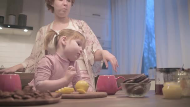Νέα Όμορφη Μητέρα Και Κόρη Πίνουν Τσάι Μπισκότα Στην Κουζίνα — Αρχείο Βίντεο