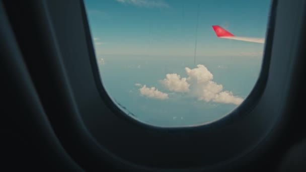 飛行機の窓から翼への眺め いい天気だ空の雲 飛行機のポールから地上への眺め 空高く雲の上を飛んでいます 乗客は航空機の窓や玄関口を見ている 一人称視点 — ストック動画