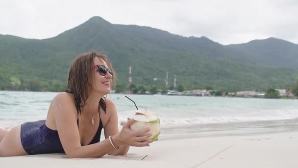 Uma Jovem Está Deitada Praia Areia Menina Está Bebendo Água — Vídeo de Stock