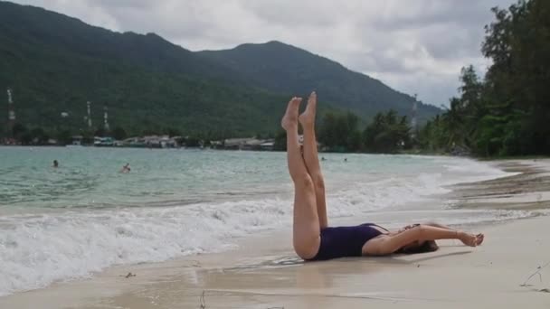 Ung Vacker Flicka Baddräkt Stranden Ligger Sanden Höj Fötterna Stranden — Stockvideo