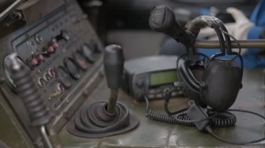 Eski bir Sovyet arazi aracının şanzımanı. Zırhlı bir personel taşıyıcısının kontrol paneli. Eski dahili telefon. Kulaklıklar bantla geri sarıldı.