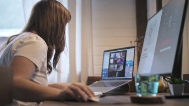 Genç güzel kadın bir dizüstü bilgisayarda çalışıyor. Gülümseyen kız öğretmen online dersler veriyor. İş videosu konferansı. Ofis evde. Kişisel izolasyon koşullarında çalış.