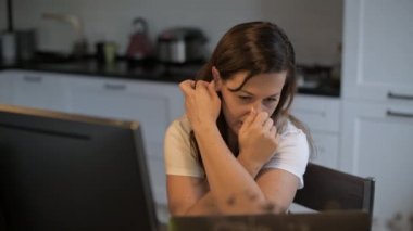 Genç, güzel bir kadın bilgisayar ekranına bakıyor. Uzaktan kumanda. Çevrimiçi öğretmenlik. Öğretmen egzersizi gösterir. Nöropsikolog uzaktan kumandayla çalışıyor. Ev eşyaları..