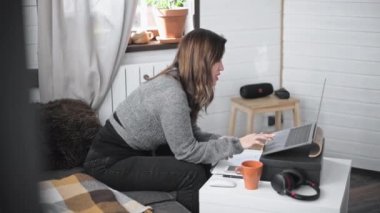 Evdeki bilgisayarın önünde çalışan genç ve güzel bir kadın. Hoş bir kız internet üzerinden ev dersleri veriyor. Evden bir iş görüşmesini yönetiyorum. İzole olanlar için çevrimiçi dersler.