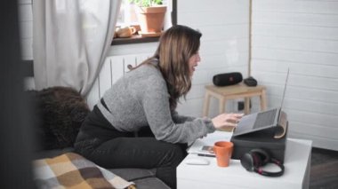 Evdeki bilgisayarın önünde çalışan genç ve güzel bir kadın. Hoş bir kız internet üzerinden ev dersleri veriyor. Evden bir iş görüşmesini yönetiyorum. İzole olanlar için çevrimiçi dersler.