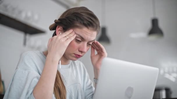 その若い美少女はノートパソコンで働いている 強い頭痛だ 側頭葉のマッサージ 動揺してる学生 悲しみの深い感情 — ストック動画