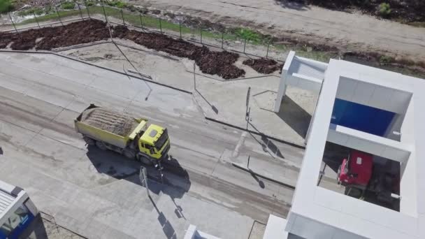 砂を積んだ黄色いトラックが検問所まで引っ張ってくる 貨物輸送 閉鎖施設での建設工事 論理的な仕事 — ストック動画