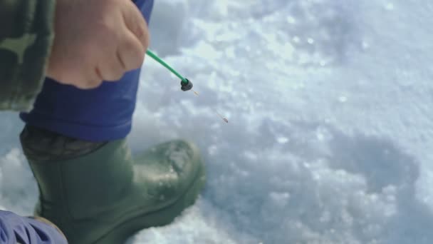 Ο άνθρωπος πιάνει ψάρια στη λίμνη του χειμώνα — Αρχείο Βίντεο