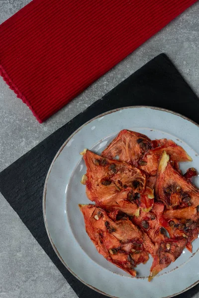 Tabağın üstünde güneşte kurutulmuş karpuz, dikey veiw.