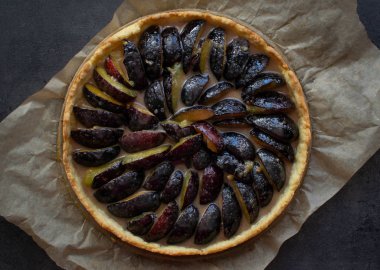 Kağıt üzerinde ev yapımı erikli turta ve koyu arkaplan. Üst görünüm.