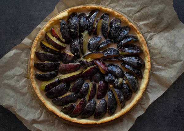 Kağıt üzerinde ev yapımı erikli turta ve koyu arkaplan. Üst görünüm.