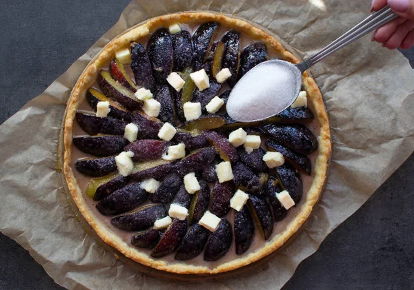 Kağıt üzerinde ev yapımı erikli turta ve koyu arkaplan. Üst Manzara. Şekerli kaşık.