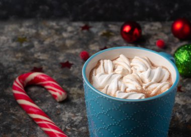 Noel ve yeni yıl kompozisyonu, koyu arkaplanda kakaolu veya çikolatalı şekerlemeli, şekerli ve kırmızı dutlu bardaklar.. 