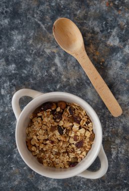 Yoğurt kasesi, beyaz kâse içinde granola, üst manzara. Sağlıklı vejetaryen kahvaltı konsepti.