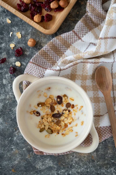 Yoğurt kasesi, beyaz kâse içinde granola, üst manzara. Sağlıklı vejetaryen kahvaltı konsepti.