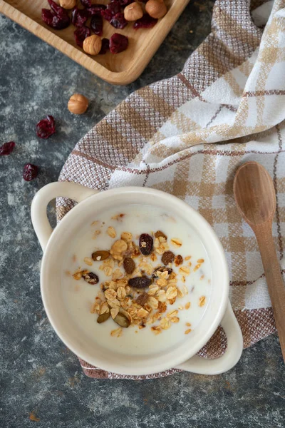 Yoghurt bowl with granola in a white bowl, top view. Healthy vegan food breakfast concept.