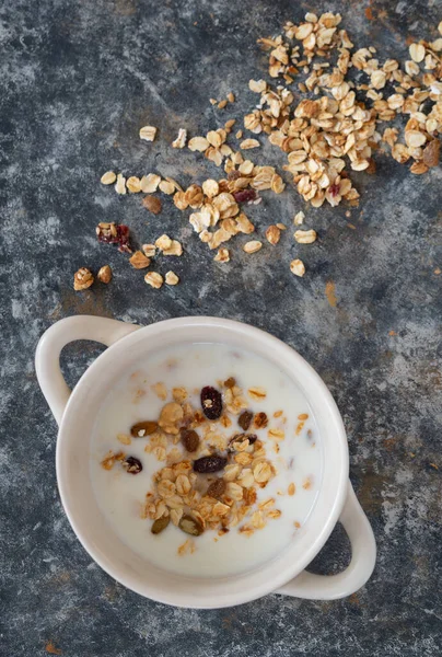 Yoğurt kasesi, beyaz kâse içinde granola, üst manzara. Sağlıklı vejetaryen kahvaltı konsepti.