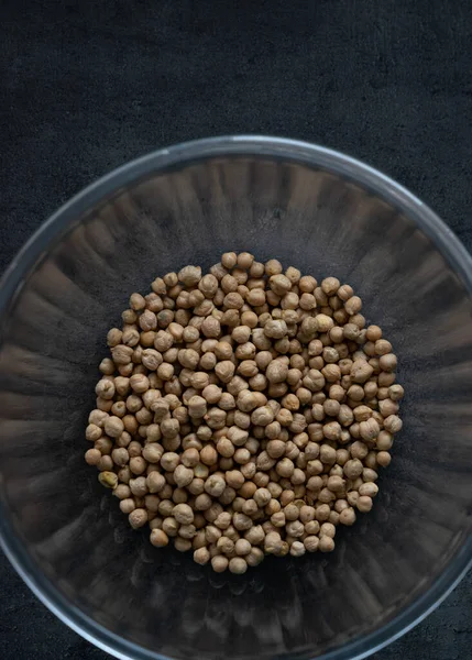 Kurutulmuş fasulye, karanlık yüzeyde cam kaseye konur.. 