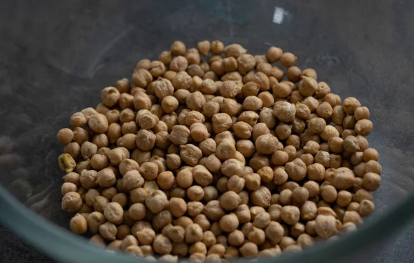 Kurutulmuş fasulye, karanlık yüzeyde cam kaseye konur.. 