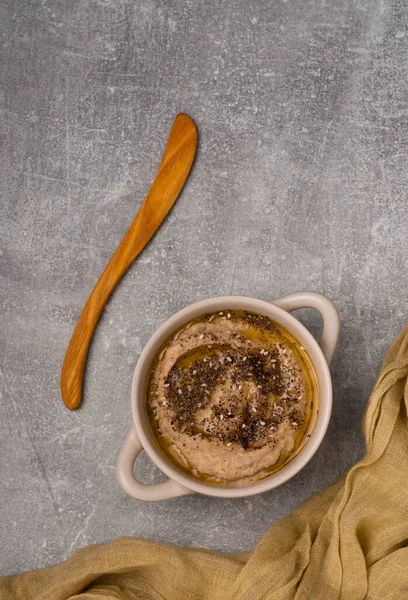 Ev yapımı humus kasesi, bitkilerle ve zeytinyağıyla süslenmiş. Üst Görünüm.