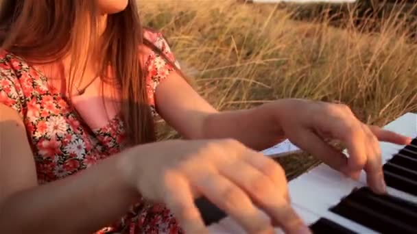 Glad ung kvinna spela piano på fältet — Stockvideo