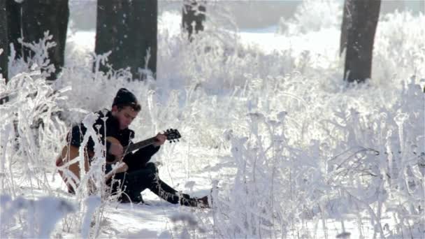 Mladý muž hraje na kytaru v parku — Stock video