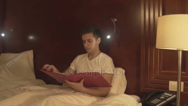 Joven tratando de relajarse leyendo la revista — Vídeos de Stock