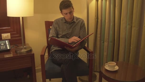 Young man trying to relax reading magazine — Stock Video