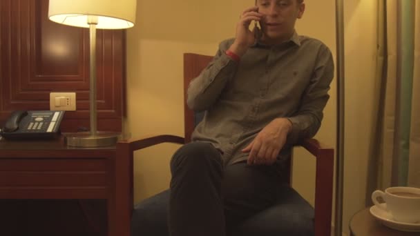 Un giovane uomo che parla al telefono in casa — Video Stock