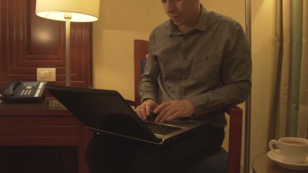 Man tekstinvoer met laptop in interieur. — Stockvideo