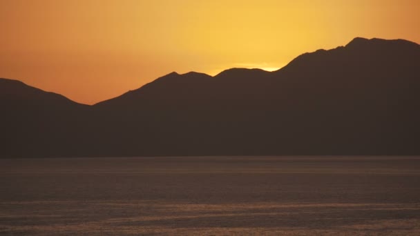 Прошло время восходящего солнца над морем и пустынными горами — стоковое видео