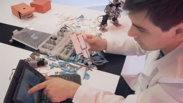 Студент створює робота в лабораторії — стокове відео