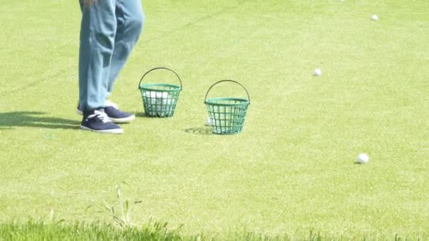 O menino coleta bolas de golfe — Vídeo de Stock