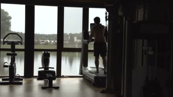 Jeune homme jogging dans la salle de gym — Video