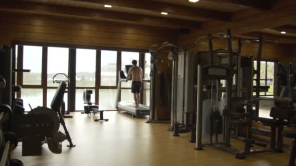 Ung man jogging i gymmet — Stockvideo