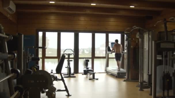 Jeune homme jogging dans la salle de gym — Video