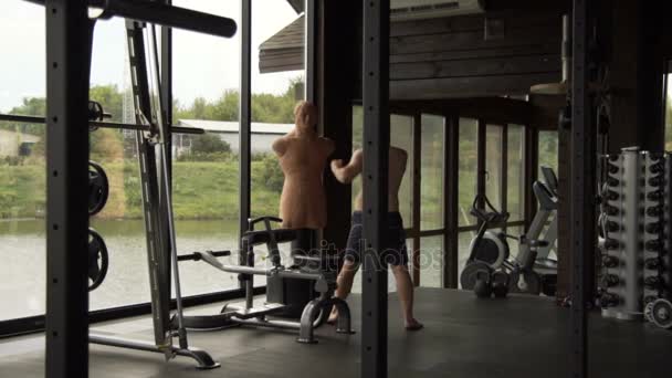 Um jovem está envolvido em boxe no ginásio — Vídeo de Stock