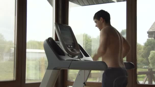 Jeune homme jogging dans la salle de gym — Video