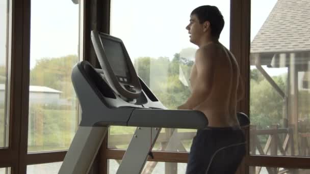 Jeune homme jogging dans la salle de gym — Video